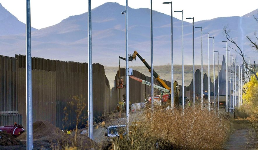 Crews construct a section of border wall in San Bernardino National Wildlife Refuge, Tuesday, Dec. 8, 2020, in Douglas, Ariz. President Biden on Wednesday ordered a "pause" on all wall construction within a week, one of 17 executive edicts issued on his first day in office, including six dealing with immigration. The order leaves projects across the border unfinished and under contract after Trump worked feverishly last year to reach 450 miles, a goal he announced was achieved eight days before leaving office. (AP Photo/Matt York)